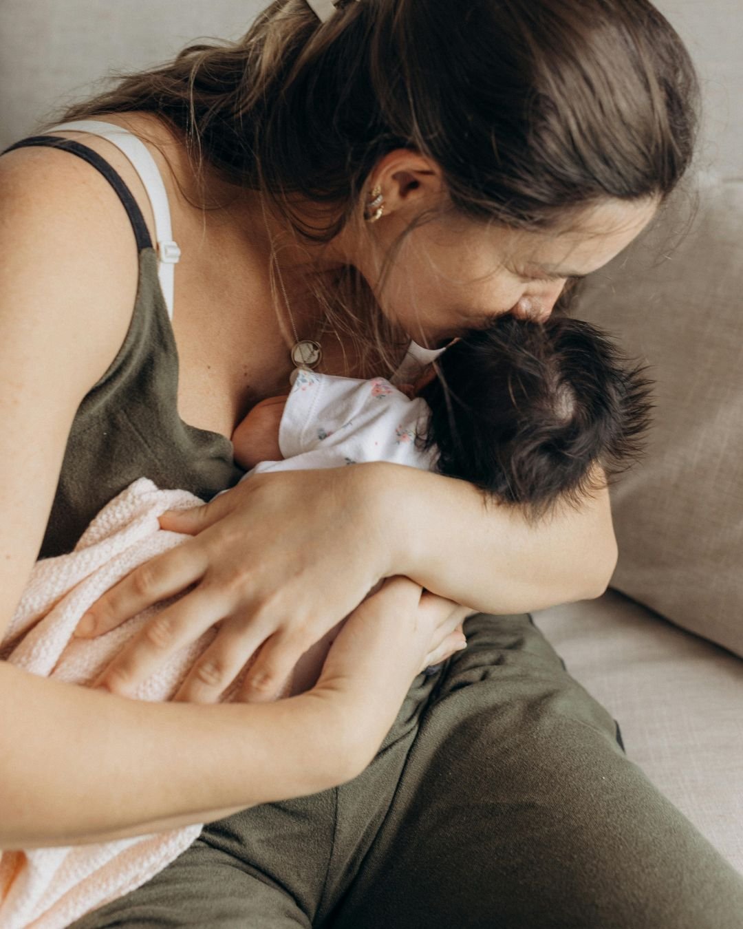 Mother resting with newborn during in-home postpartum care on the Sunshine Coast